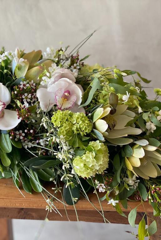 ramo de condolencias tonos verdes, amarillos, orquideas