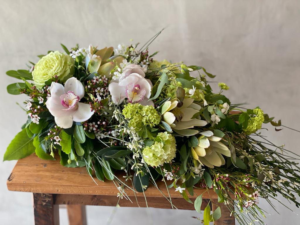 ramo de condolencias tonos verdes, amarillos, orquideas